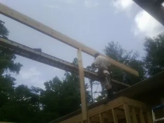 Carpenter setting a ridge beam over a new addition frame — Ice Dam Removal by Roofing Brothers in Sturtevant
